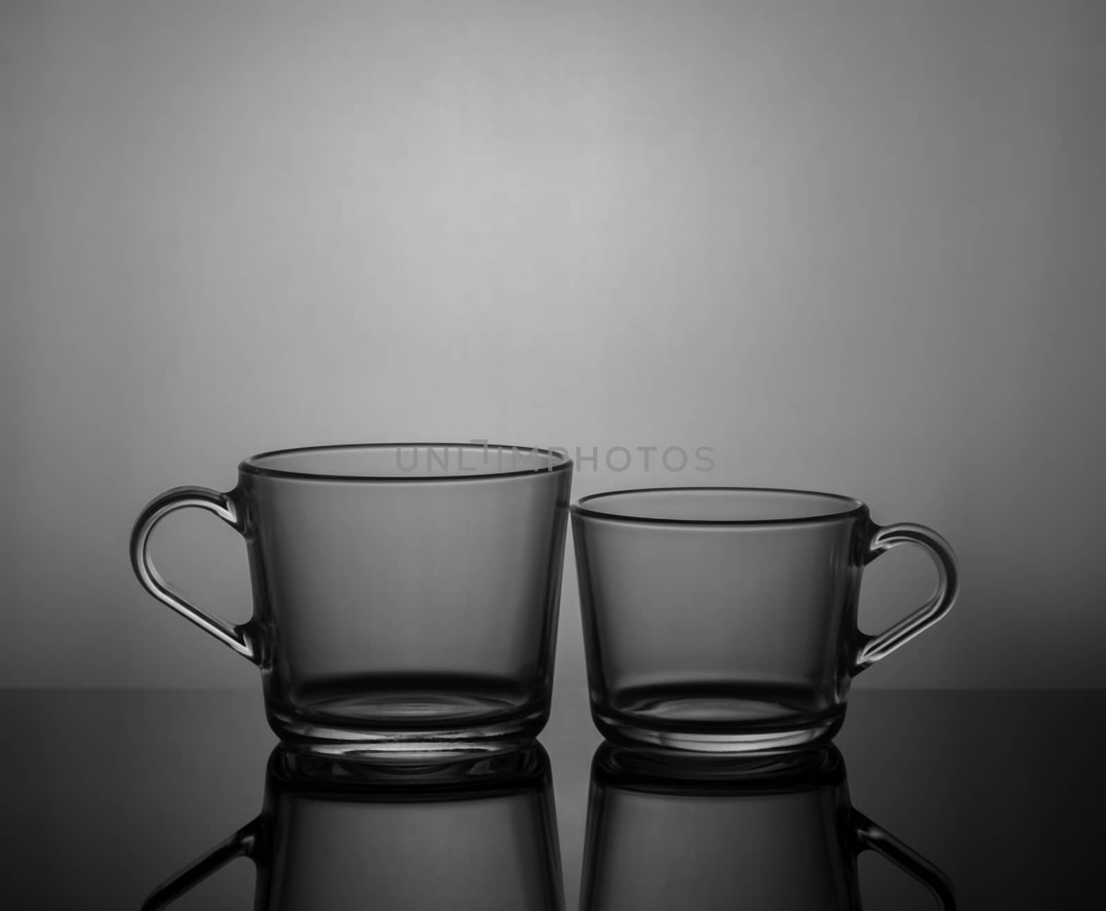 Empty tea cups on dark background with back light.