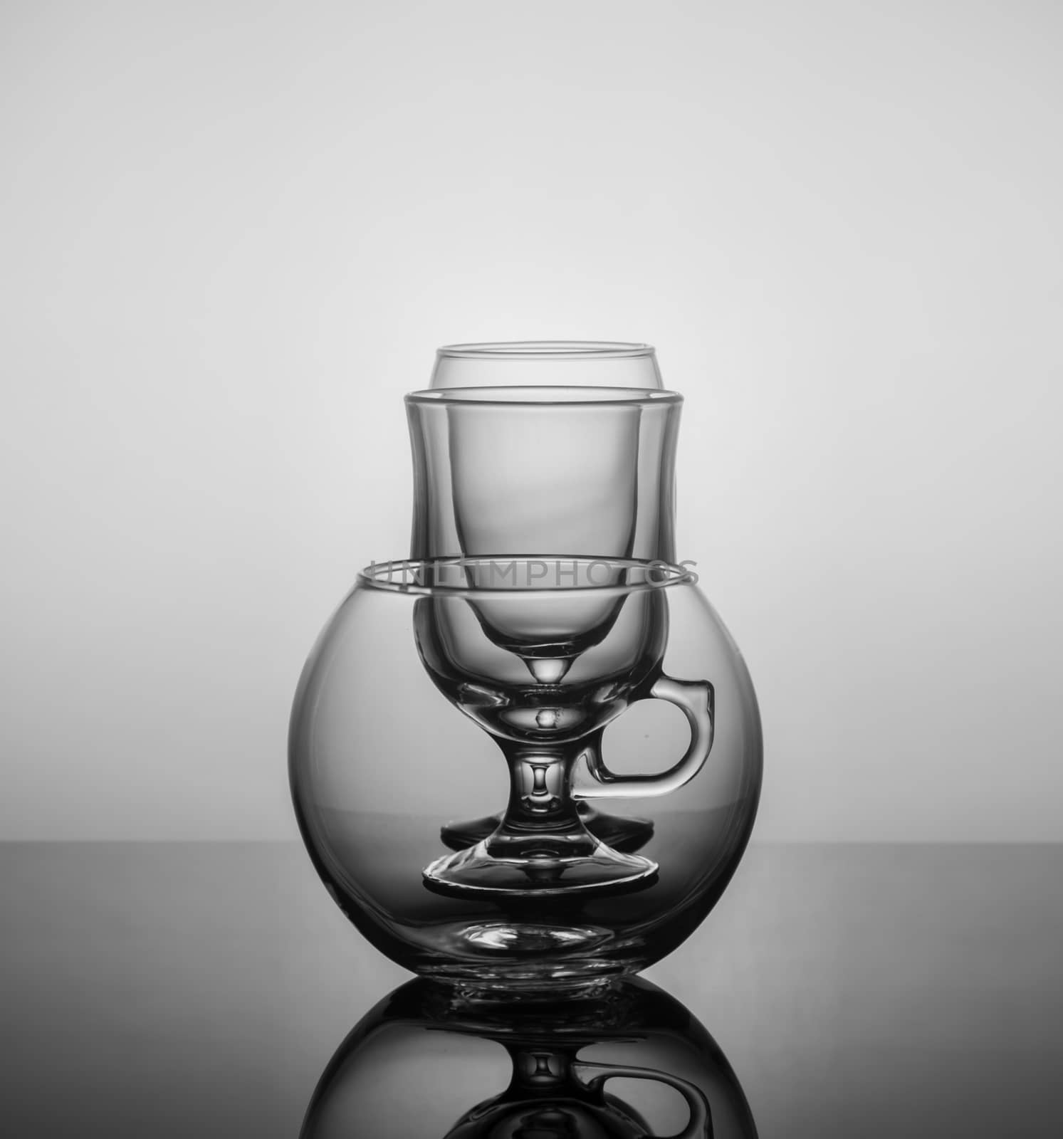 empty drink glasses placed one after another on dark background with back light.