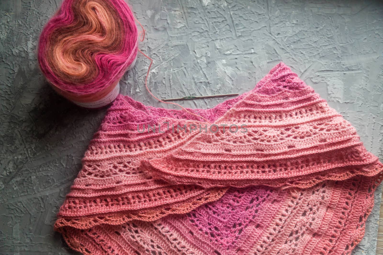 Crochet background flatlay. Crochet hook and scarf on a concrete background by galinasharapova