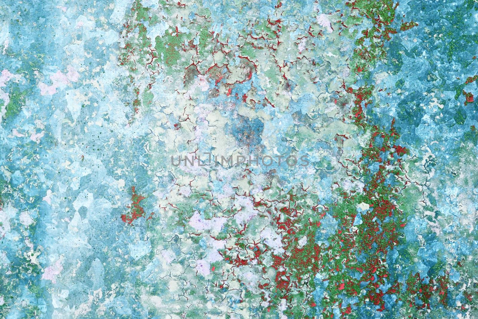 Detailed and colorful close up at cracked and peeling paint on concrete wall textures in high resolution.