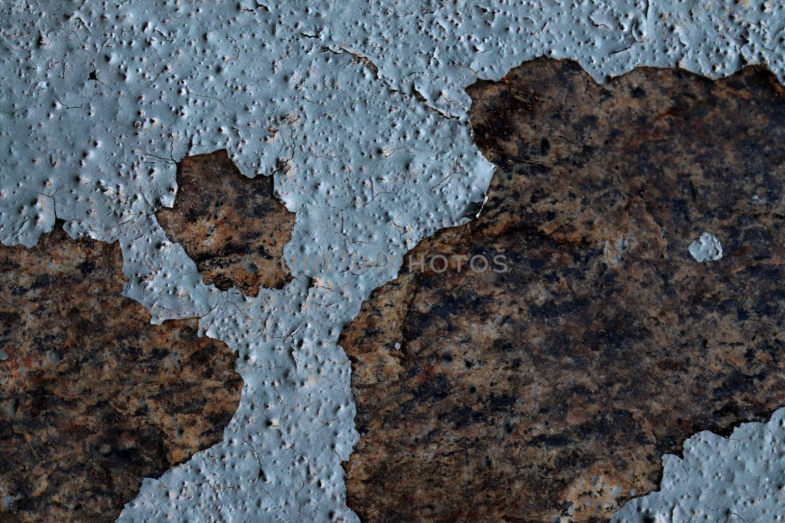 Detailed and colorful close up at cracked and peeling paint on concrete wall textures in high resolution.