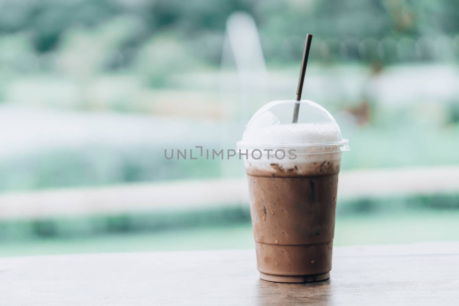 Close up glass of ice chocolate on wood table, selective focus