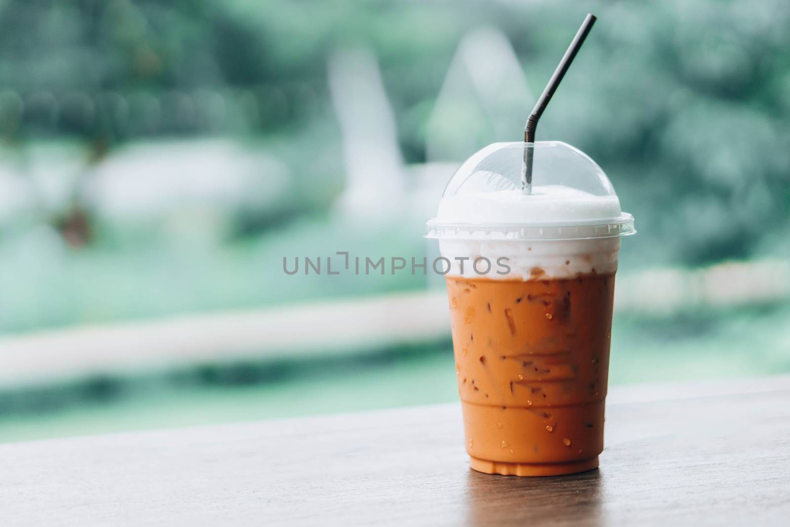 Closeup thai milk tea on wood table with nature background