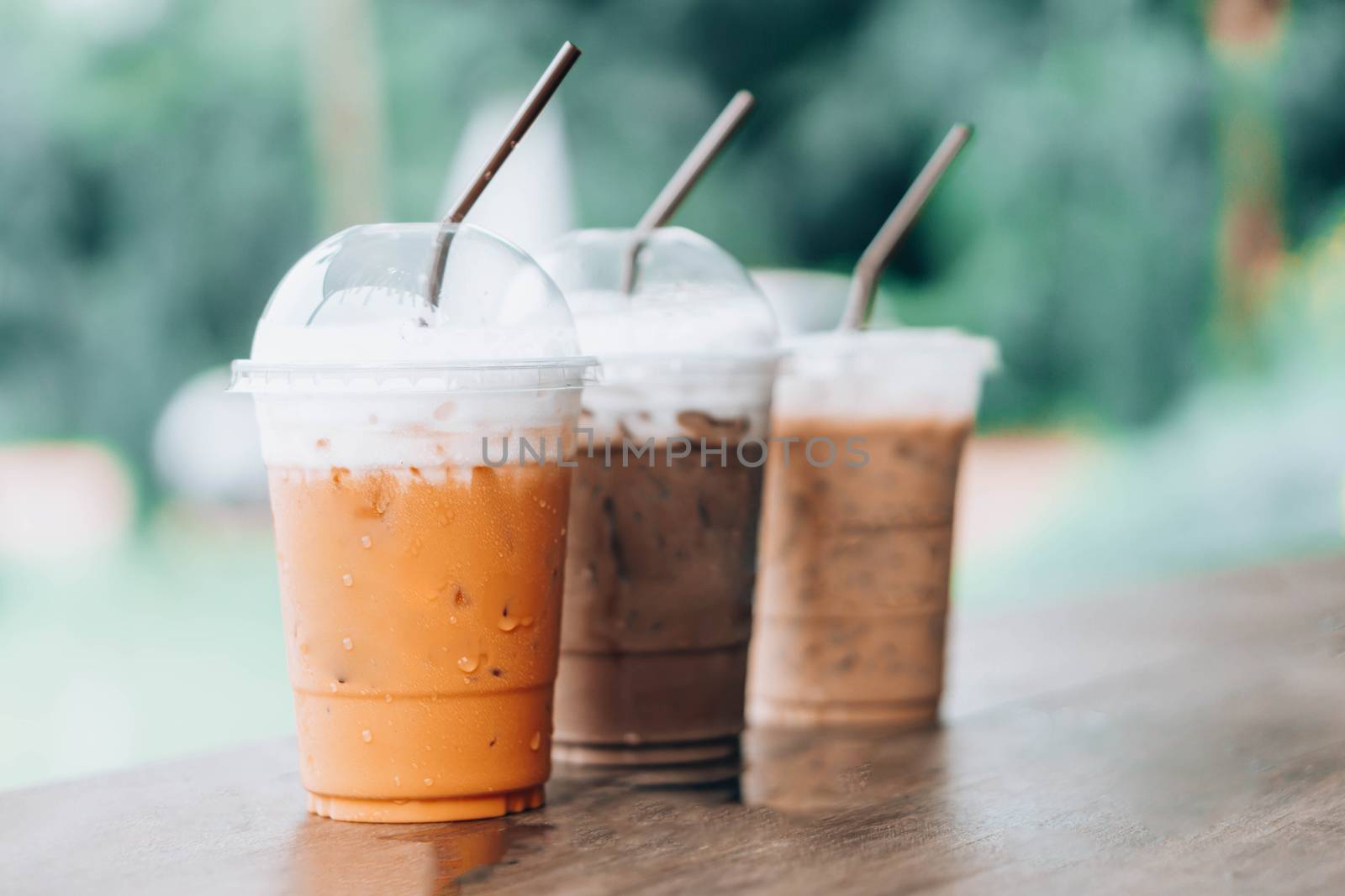 Closeup thai milk tea and chocolate on wood table with nature background