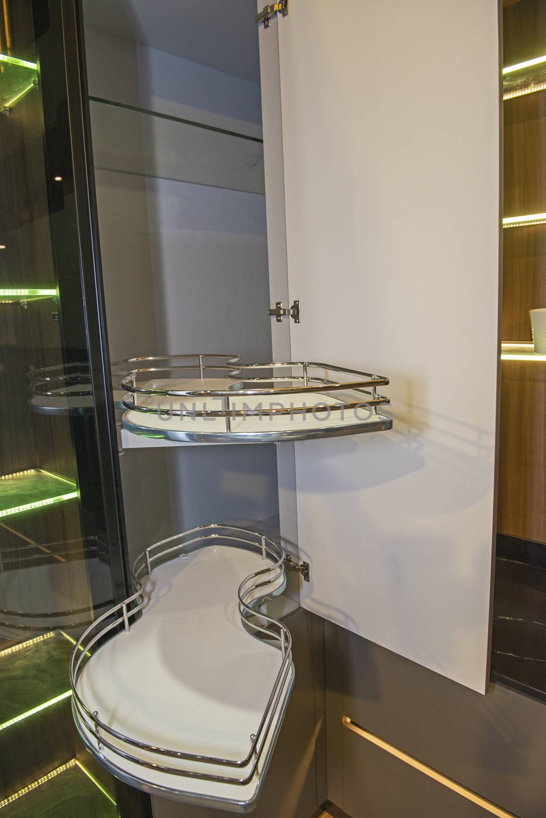 Interior design decor of kitchen in luxury apartment showing closeup detail of sliding carousel cupboard with shelves