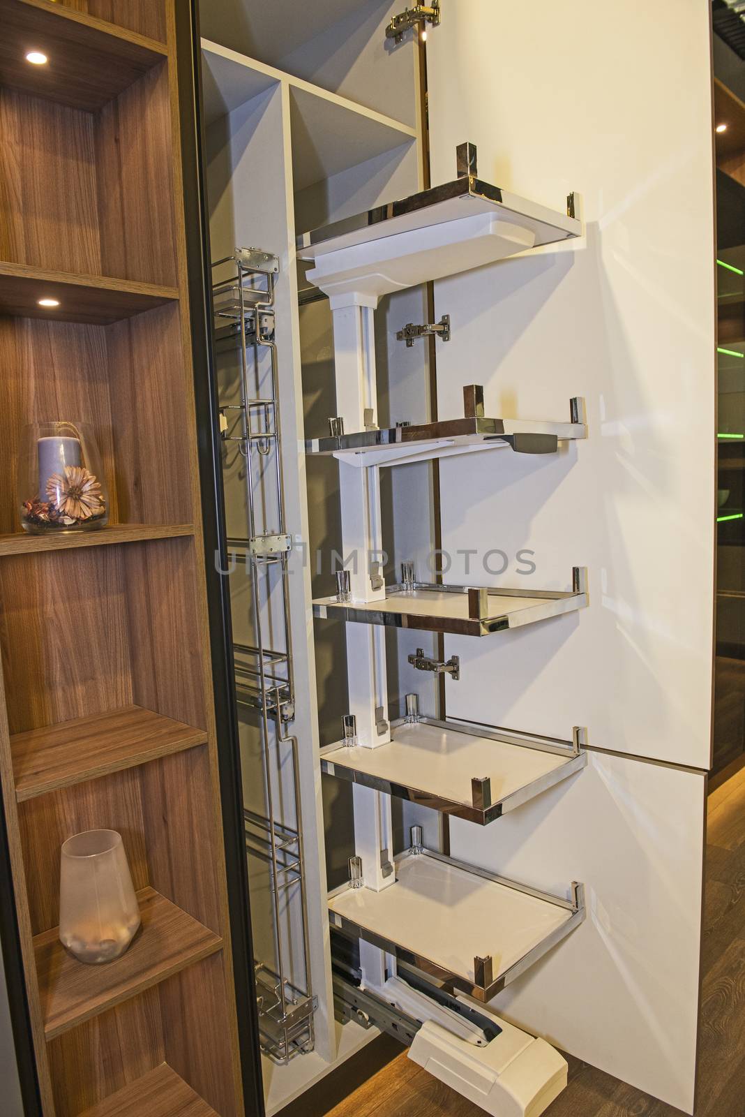 Interior design decor of kitchen in luxury apartment showing closeup detail of sliding cupboard unit with shelves