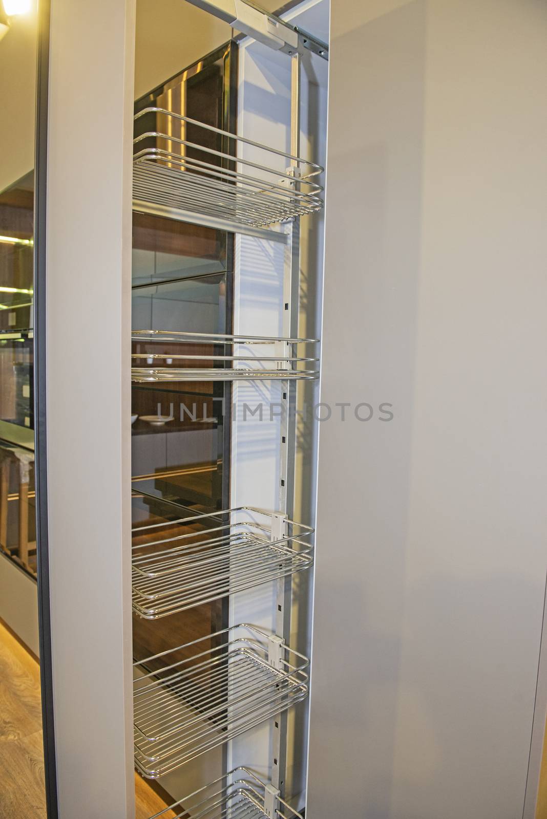 Interior design decor of kitchen in luxury apartment showing closeup detail of sliding pantry cupboard with shelves