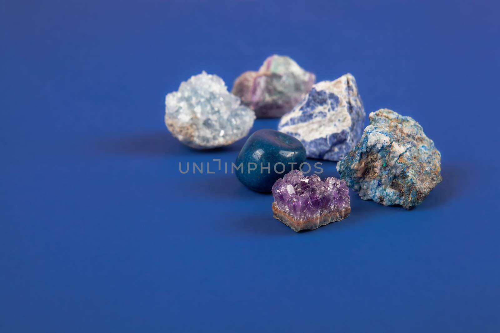 set of close up Natural minerals, precious stones on classic blue background. Use for jewelry. Space for text.