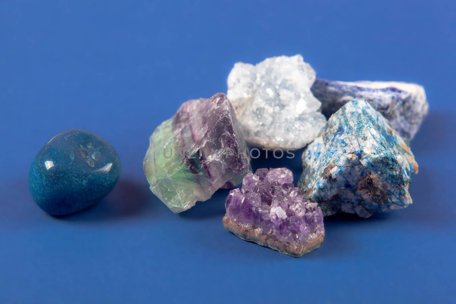 set of close up Natural minerals, precious stones on classic blue background. Use for jewelry. Space for text.