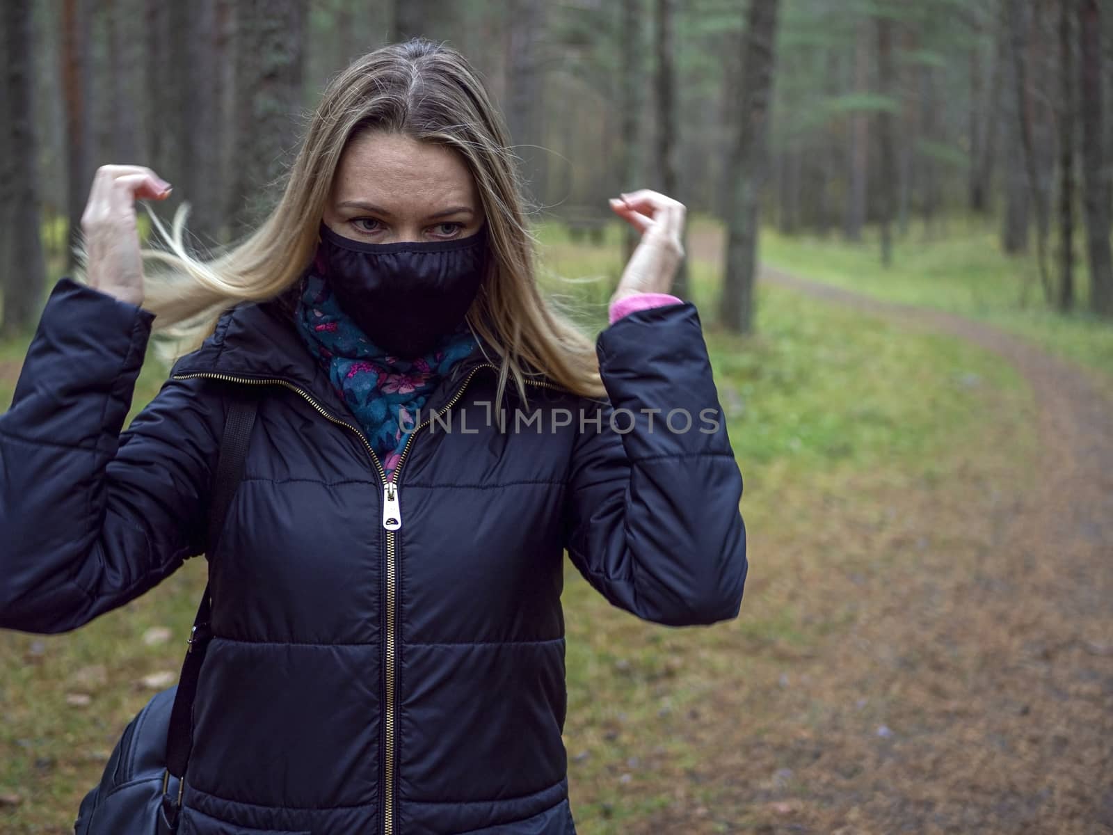 Beautiful european Women Wearing Protective Mask Outside Pretty young girl in medical black face mask in a forest. covid19 concept. modern reality. copy space. 2020, allergy. Autumn season. Copy space