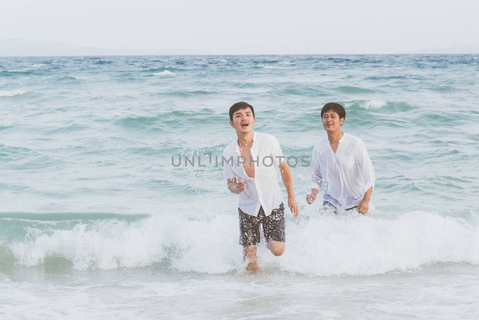 Homosexual portrait young asian couple running with cheerful together on beach in summer, asia gay going tourism for leisure and relax with happiness in vacation at sea, LGBT legal concept.