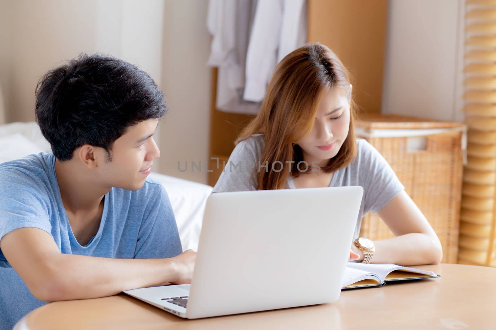 Beautiful young asian couple calculate expenses finance with laptop and planning together, woman writing notebook or note budget household, lifestyle family and business concept.