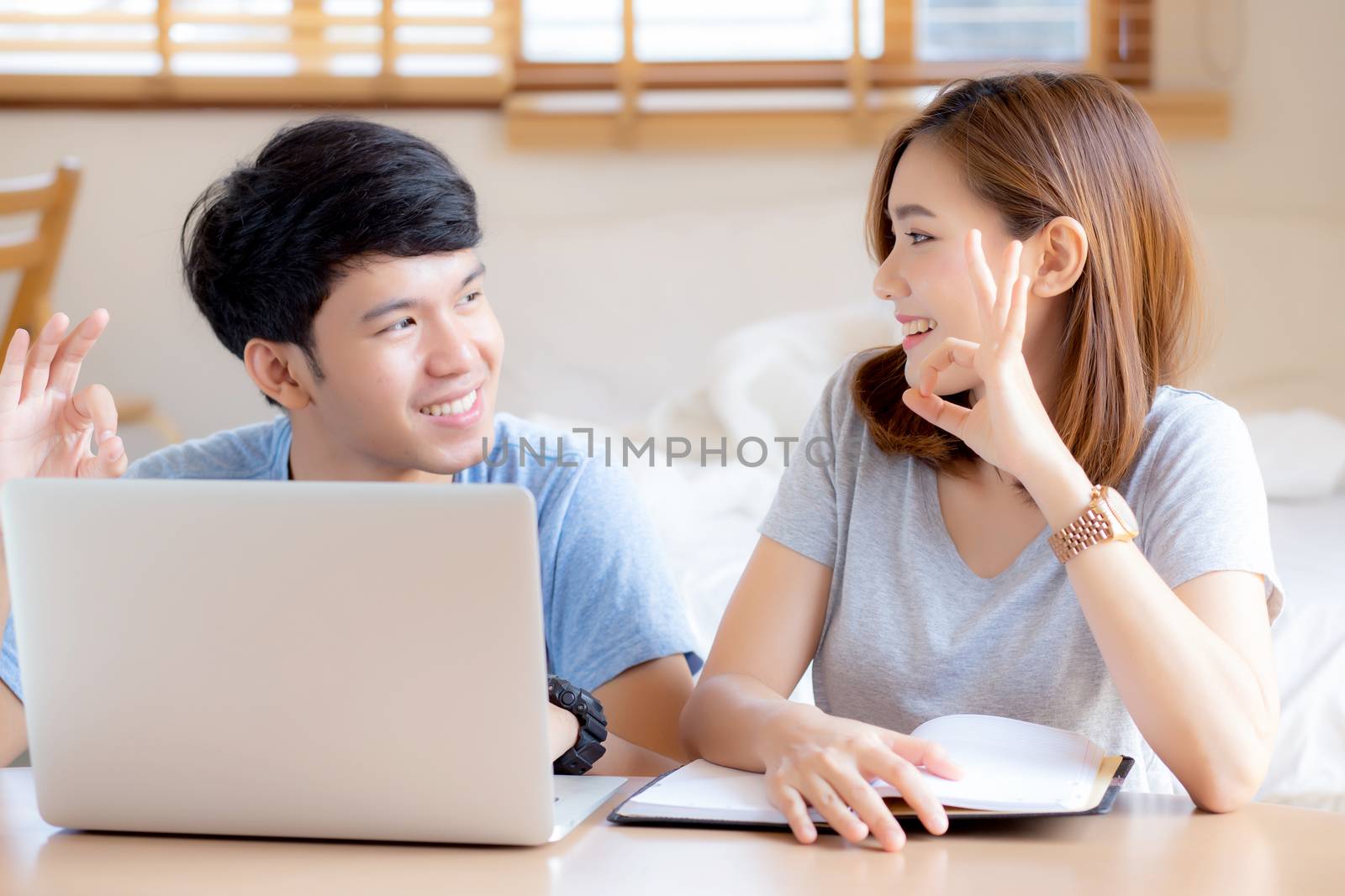 Beautiful portrait young asian couple working laptop with smile  by nnudoo