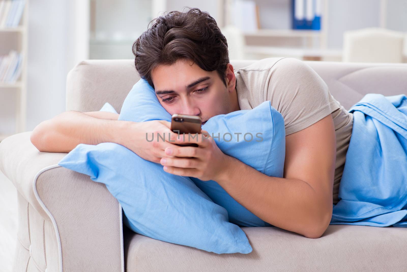Man addicted to his mobile phone in bed
