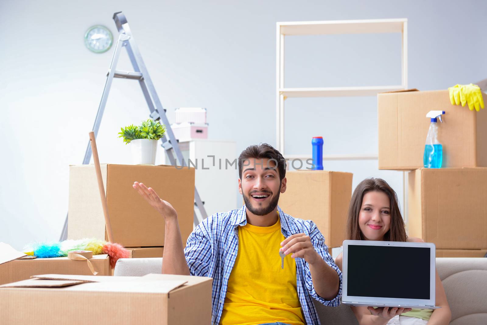 Young family unpacking at new house with boxes