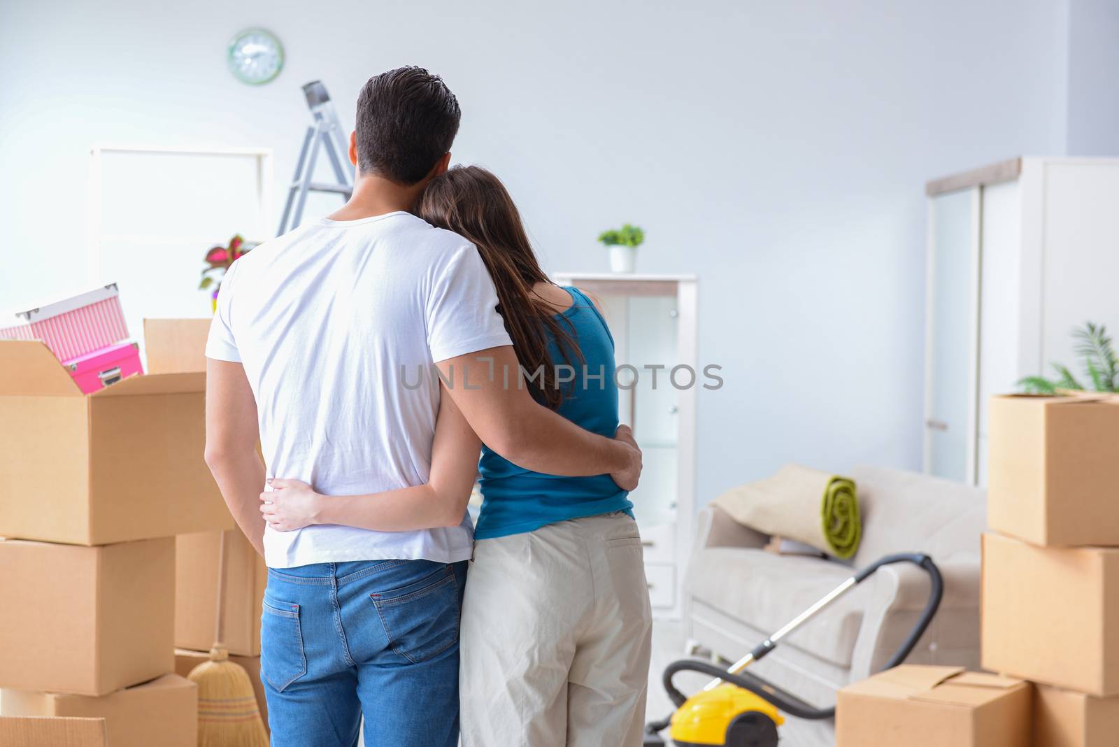 Young family unpacking at new house with boxes