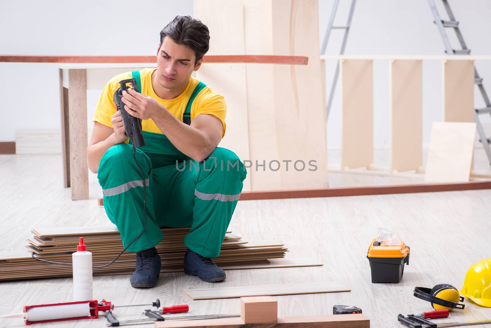 Contractor working on laminate wooden floor 