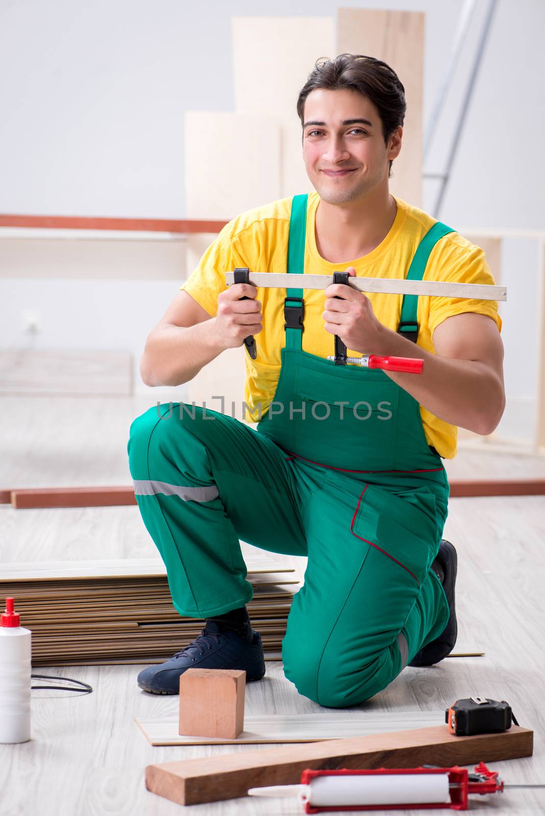 Contractor working on laminate wooden floor 