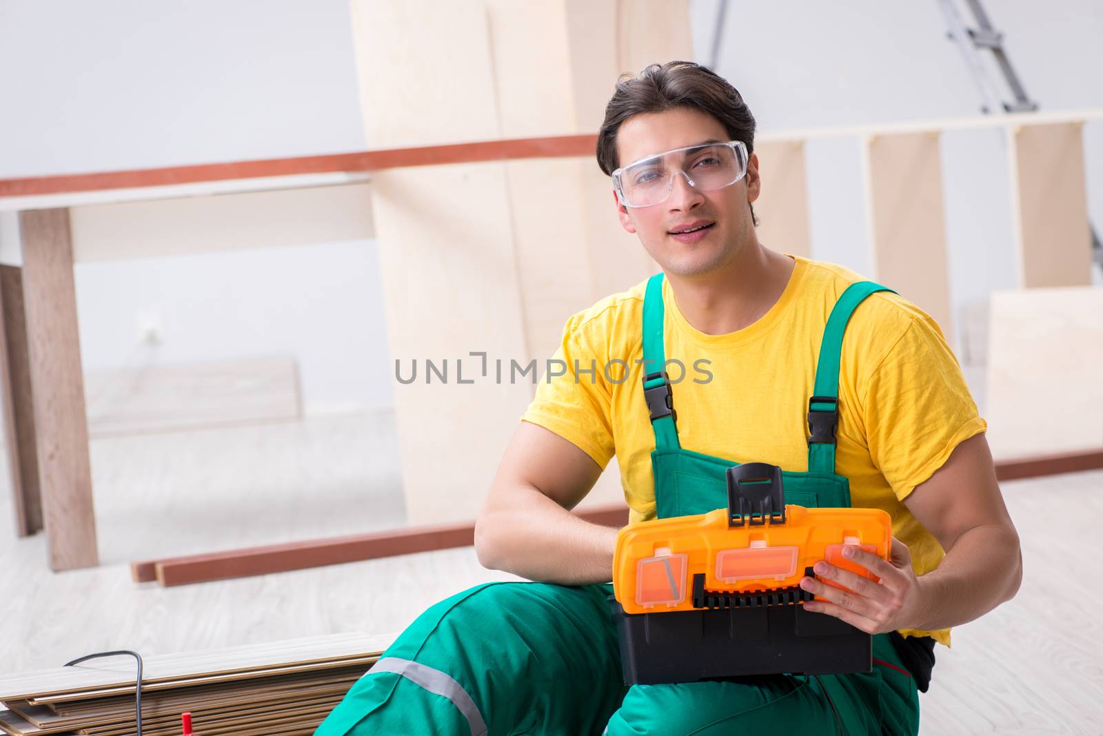 Contractor working on laminate wooden floor 