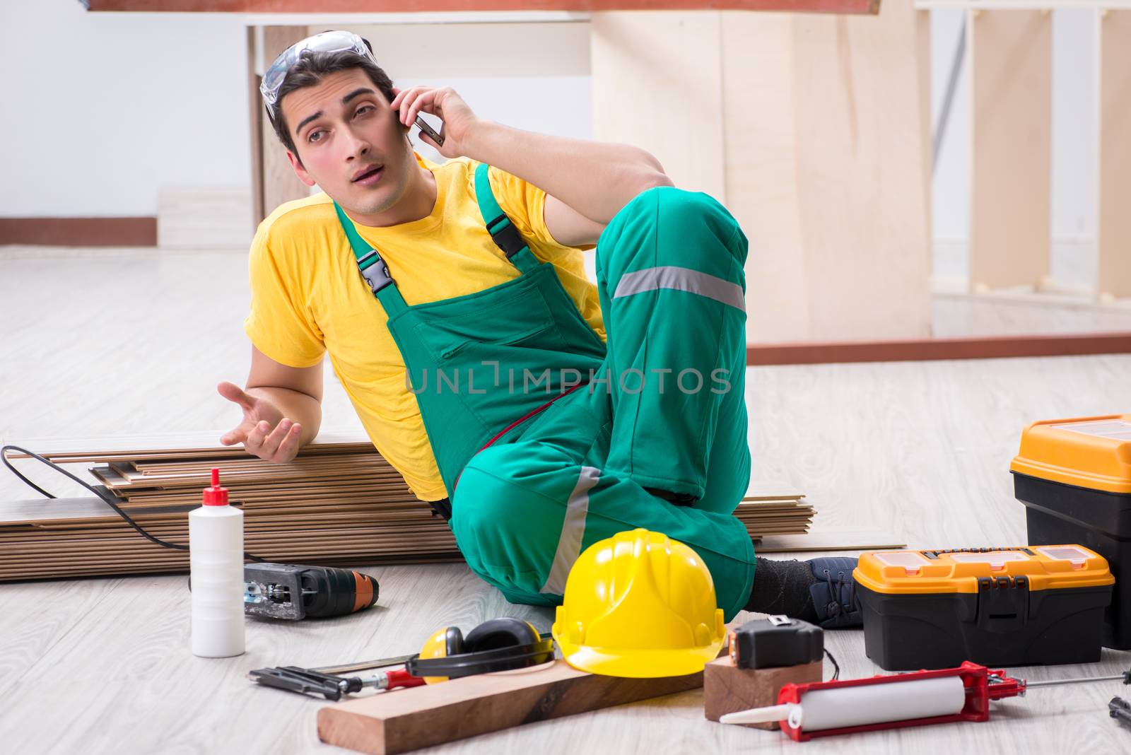 Contractor working on laminate wooden floor 