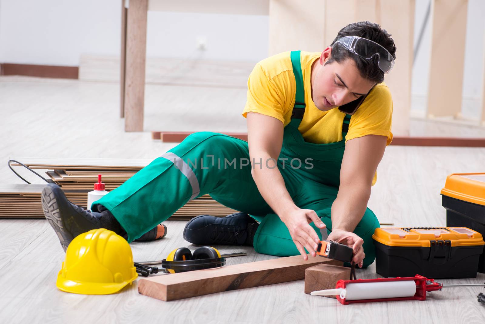 Contractor working on laminate wooden floor 