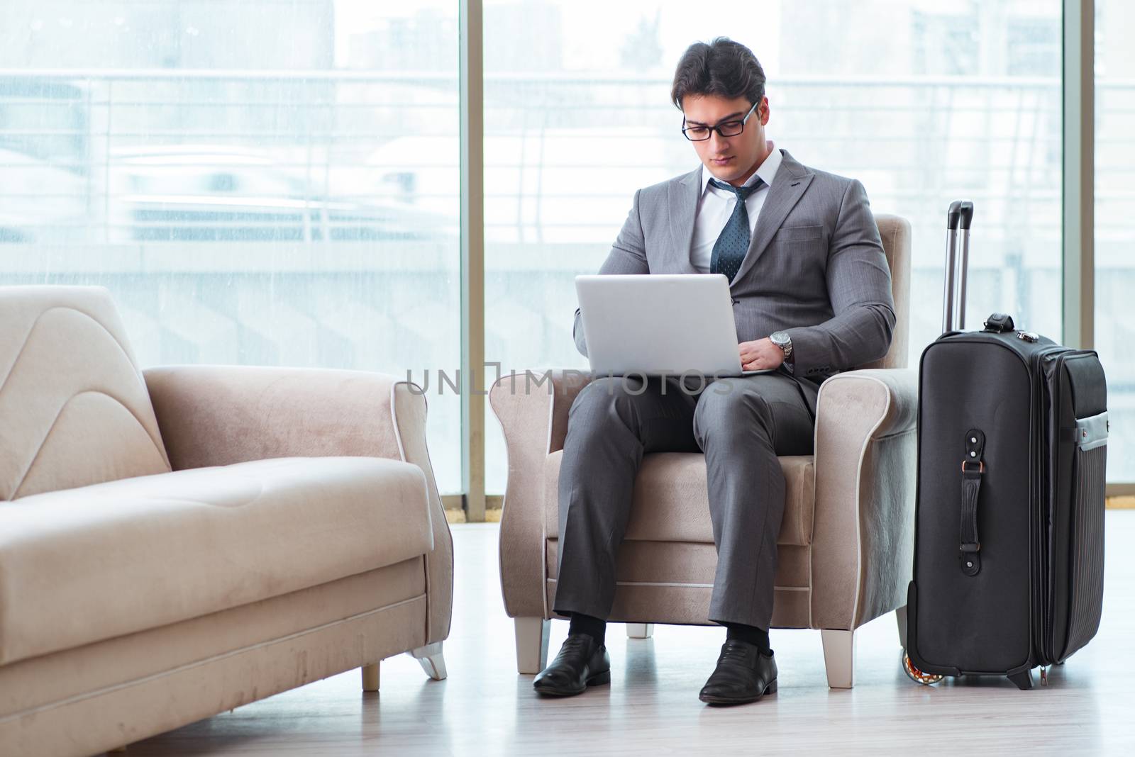 Young businessman in airport business lounge waiting for flight