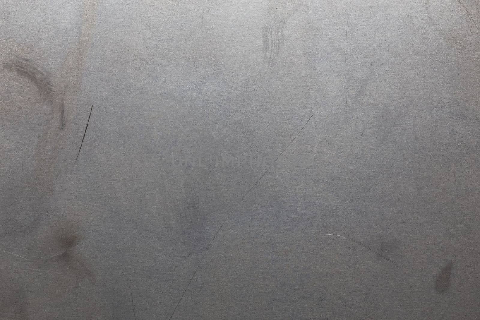Uncoated flat cold rolled metal sheet surface with minor scratches. Close-up in directly above composition.
