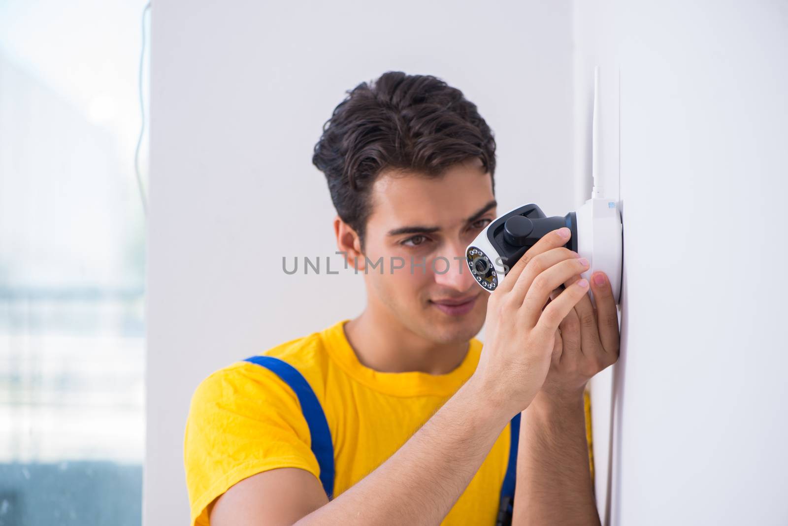 Contractor installing surveillance CCTV cameras in office