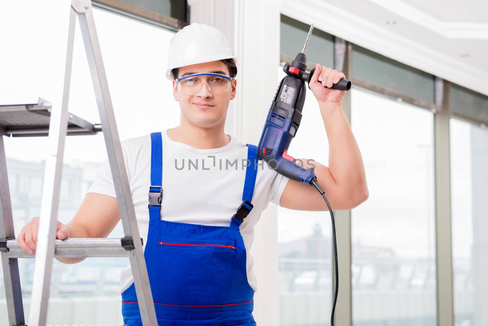 Repairman working with power drill in workshop
