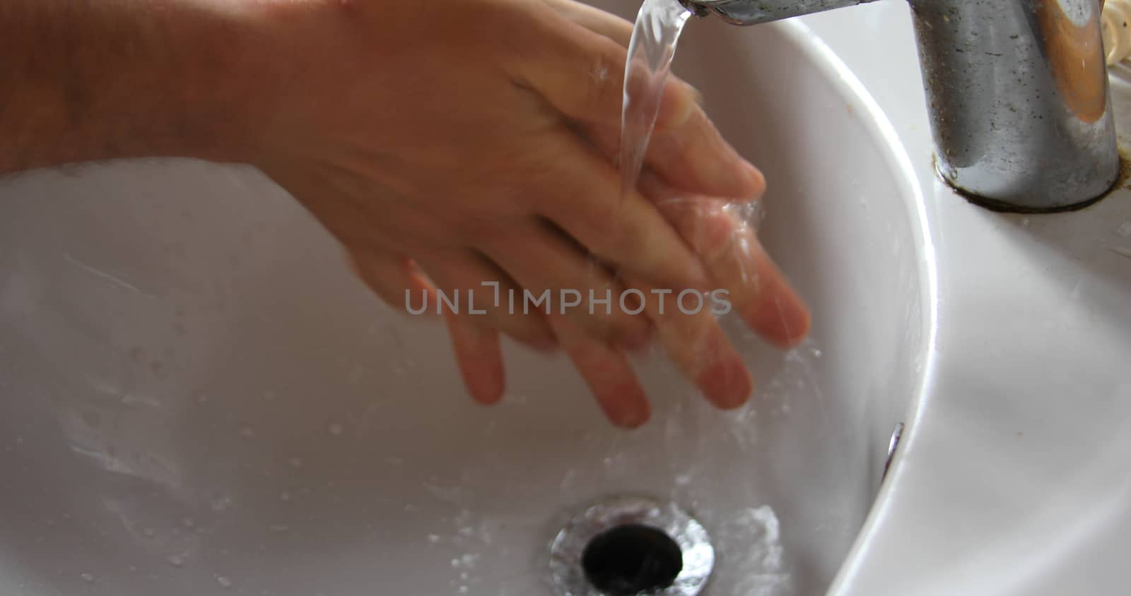 Man washes his hands thoroughly in the sink