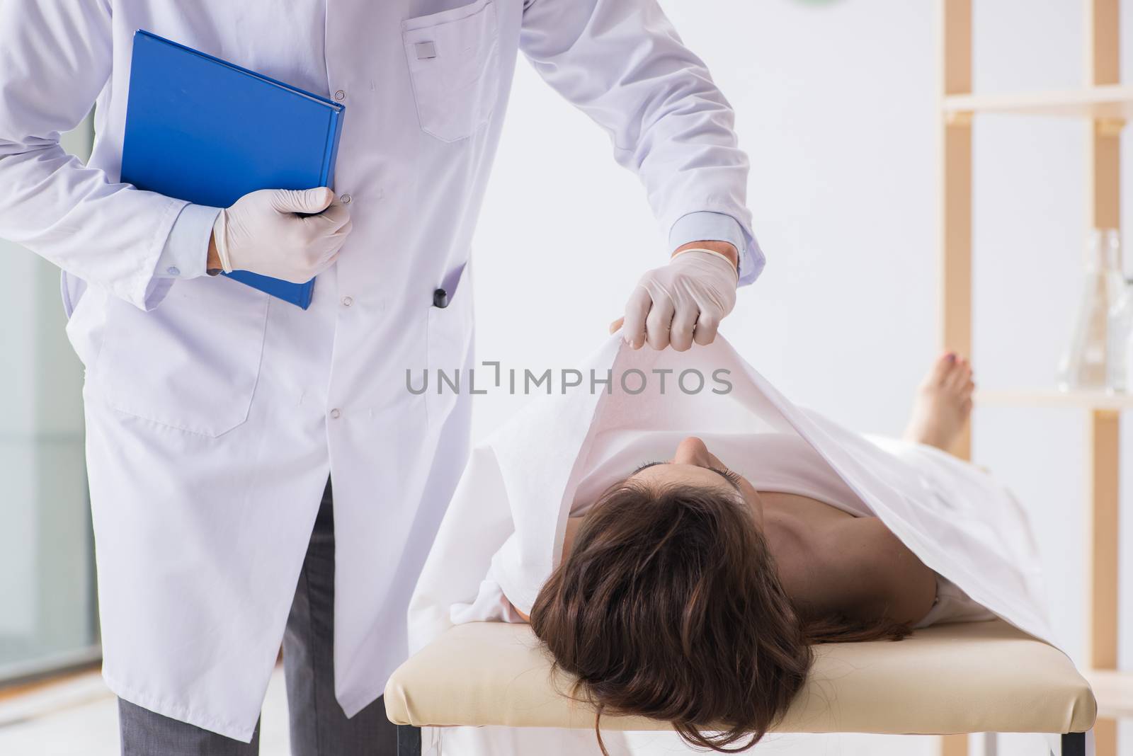 Police coroner examining dead body corpse in morgue