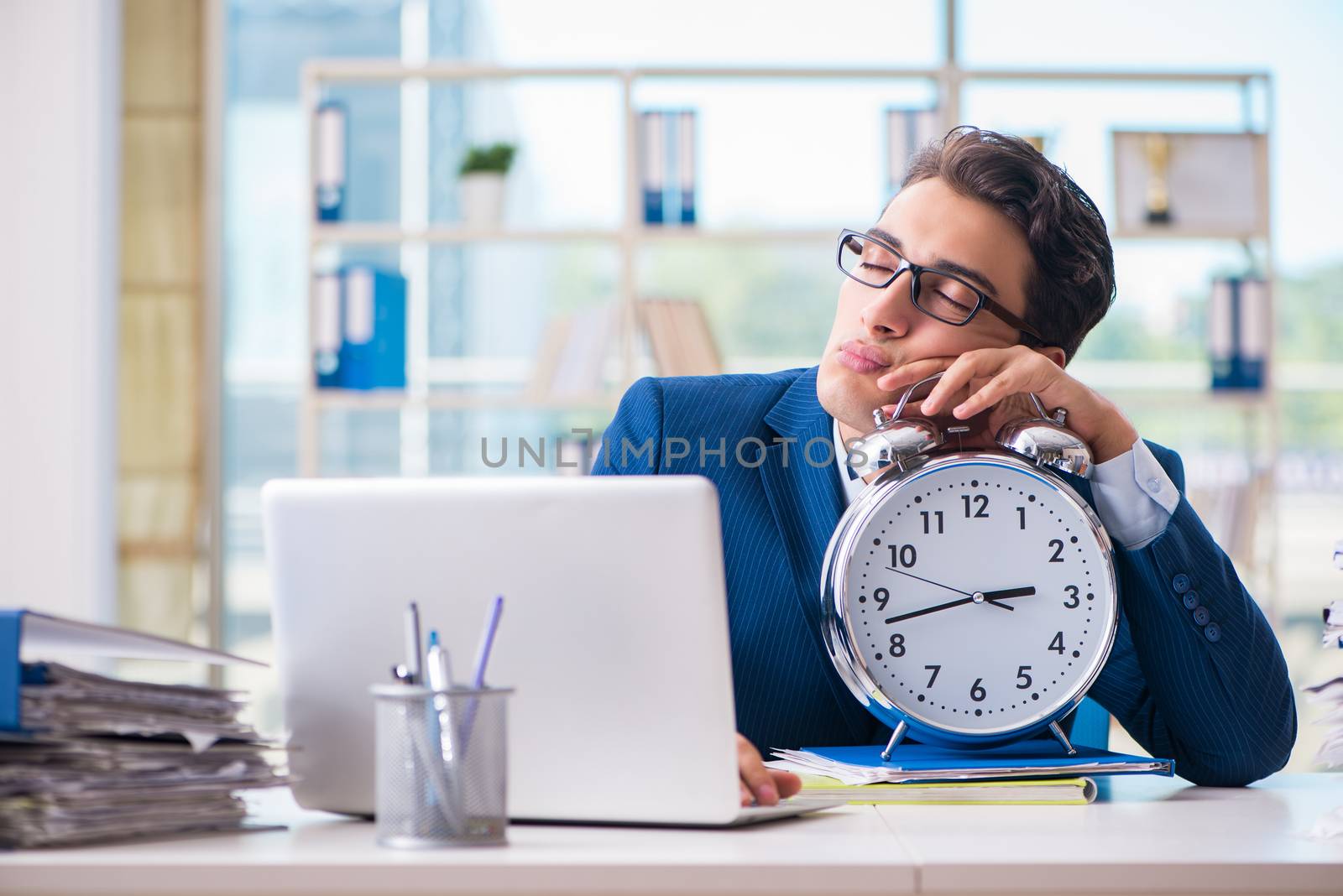 Businessman with giant clock failing to meet deadlines and missing them