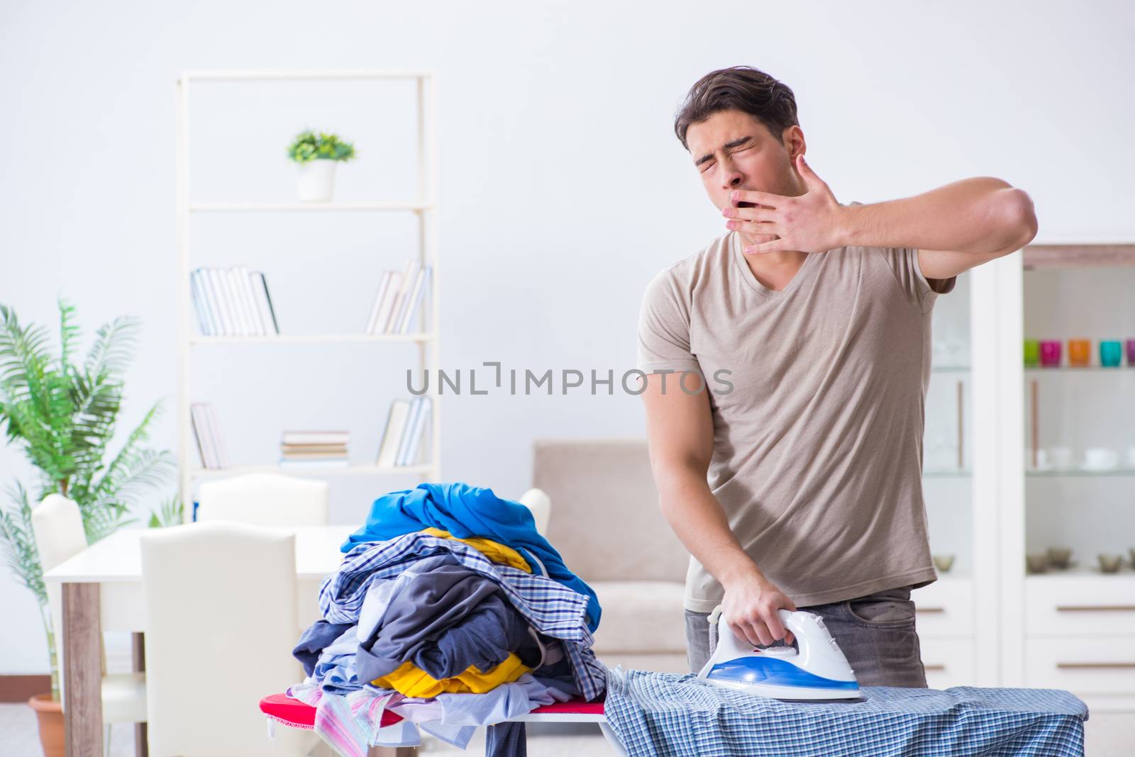 Young man husband doing clothing ironing at home