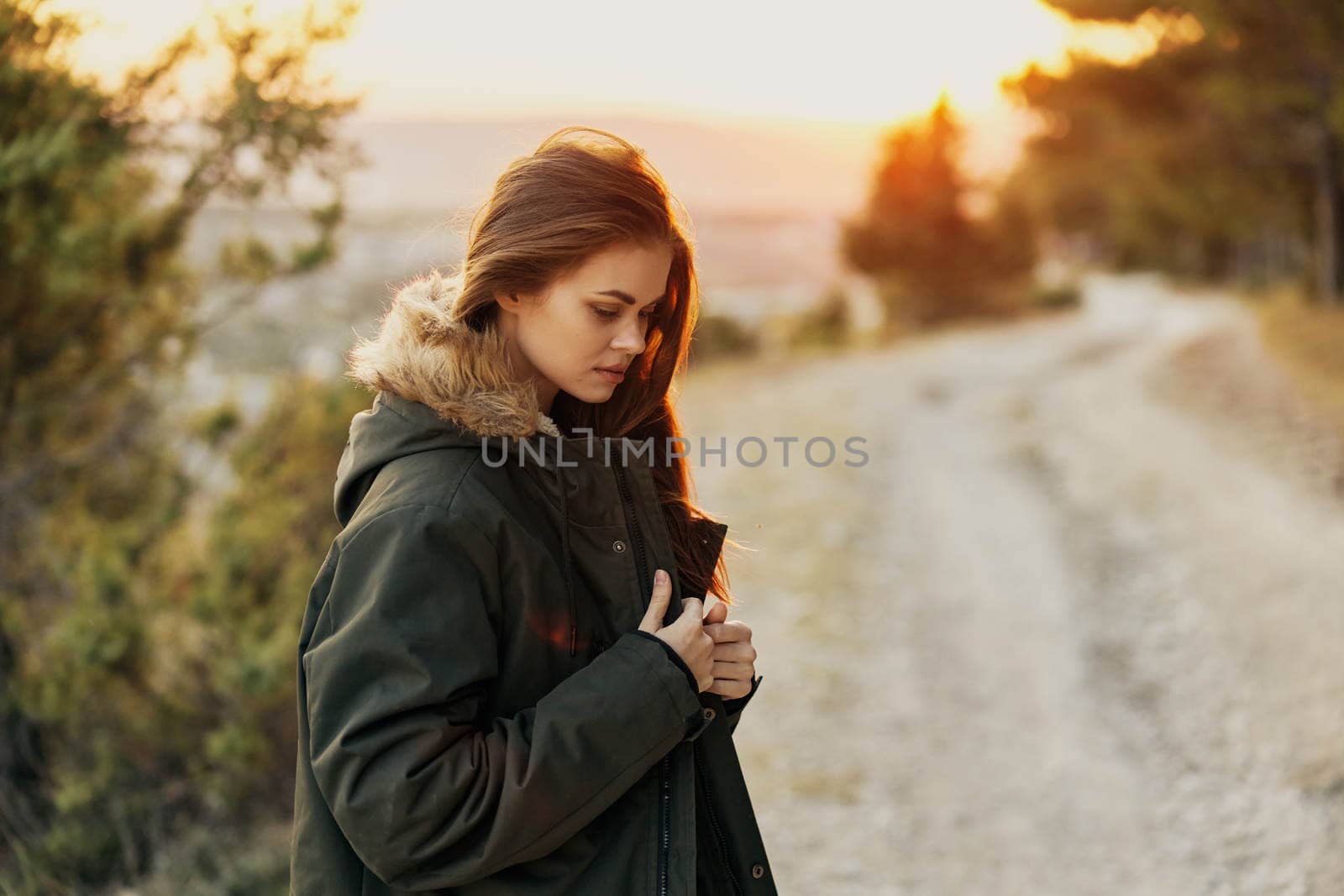 Pretty woman in warm jacket on nature fresh air travel sun. High quality photo