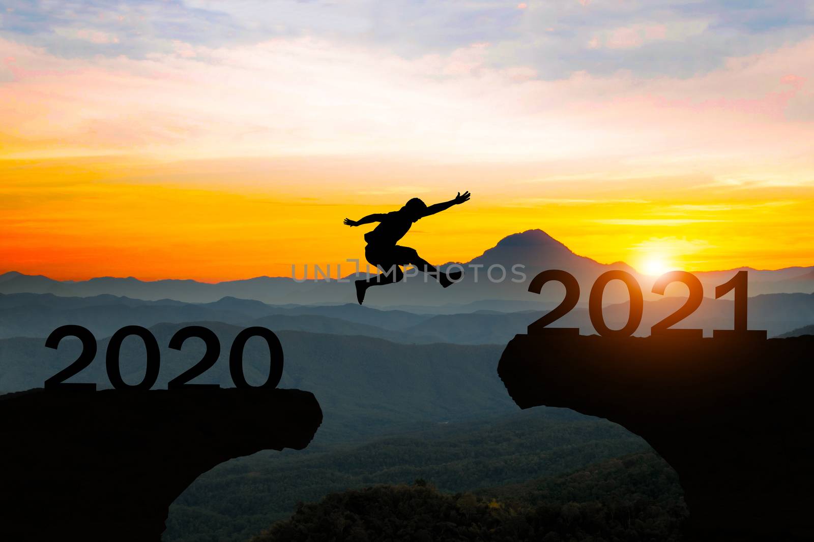 Man jump silhouette between year 2020 and 2021 new year concept. by sompongtom