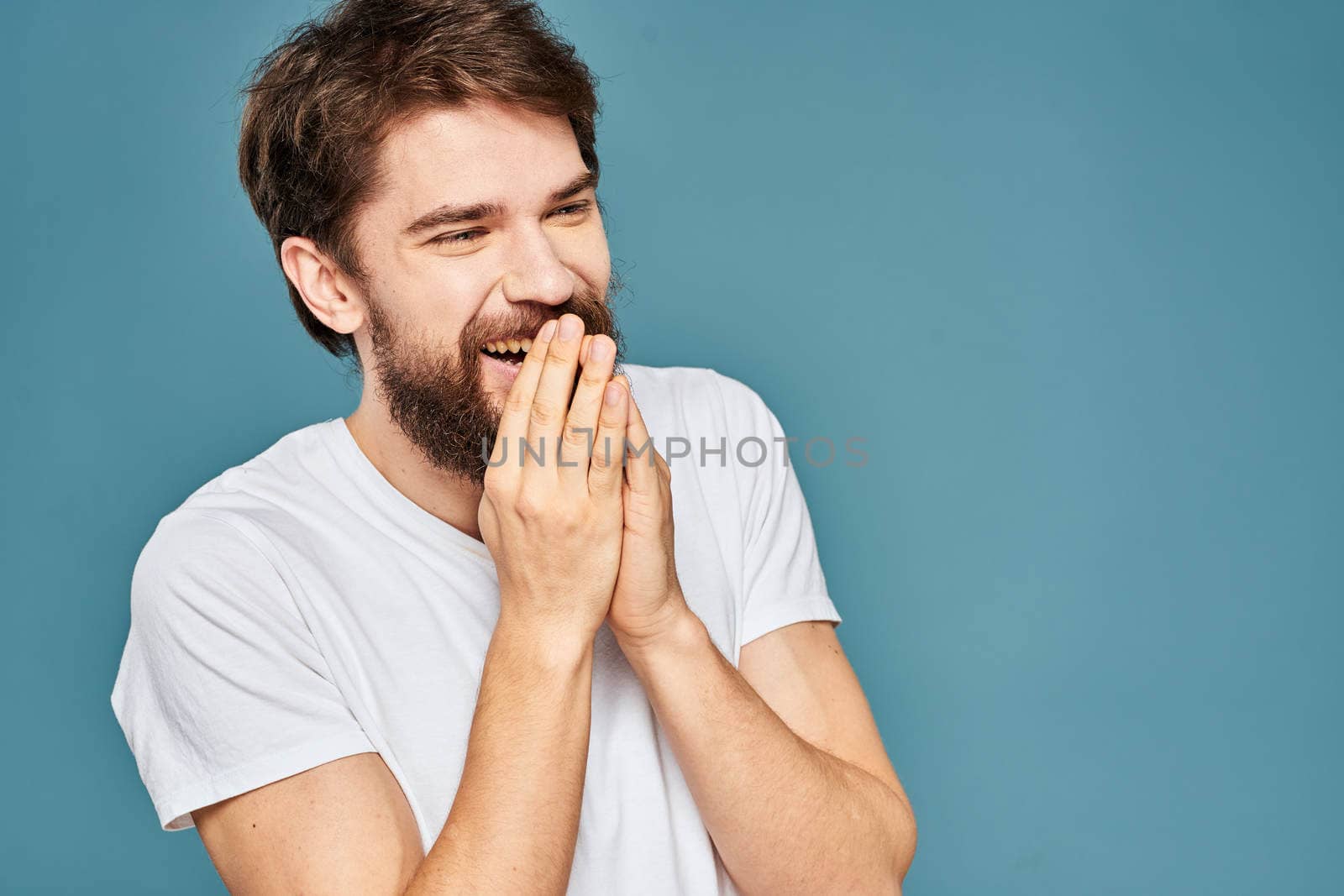 emotional man gesturing with hands lifestyle fun white t-shirt blue isolated stock. High quality photo