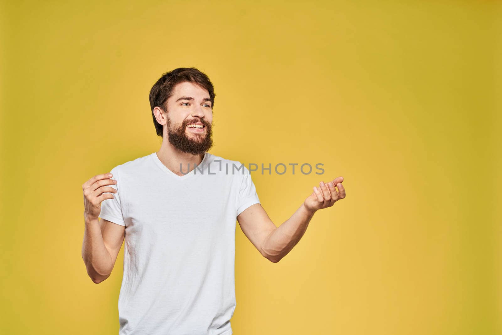 Man gesturing with hands emotions lifestyle white t-shirt yellow isolated background by SHOTPRIME