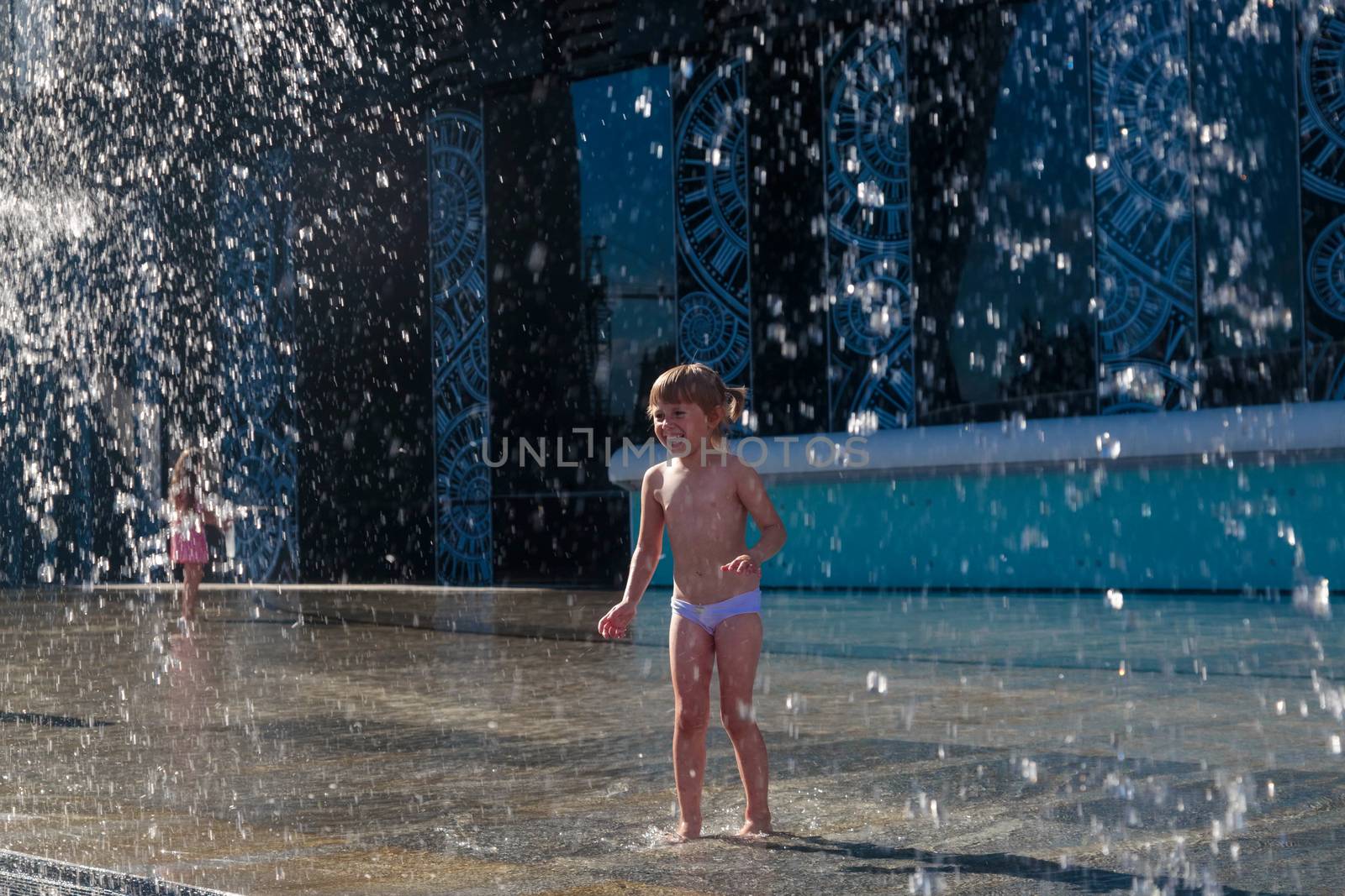 A little girl splashes water from a fountain on the territory of the Moscow city by galinasharapova