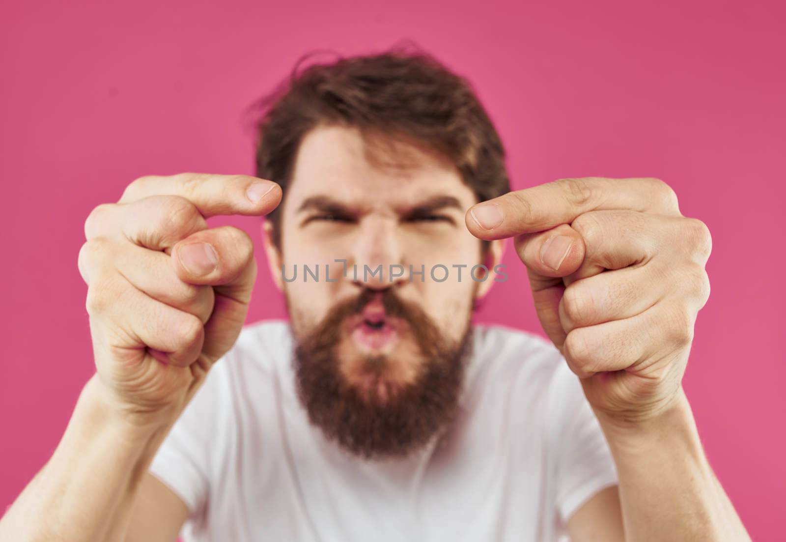 man shows thumb to the side on pink background stress irritability. High quality photo
