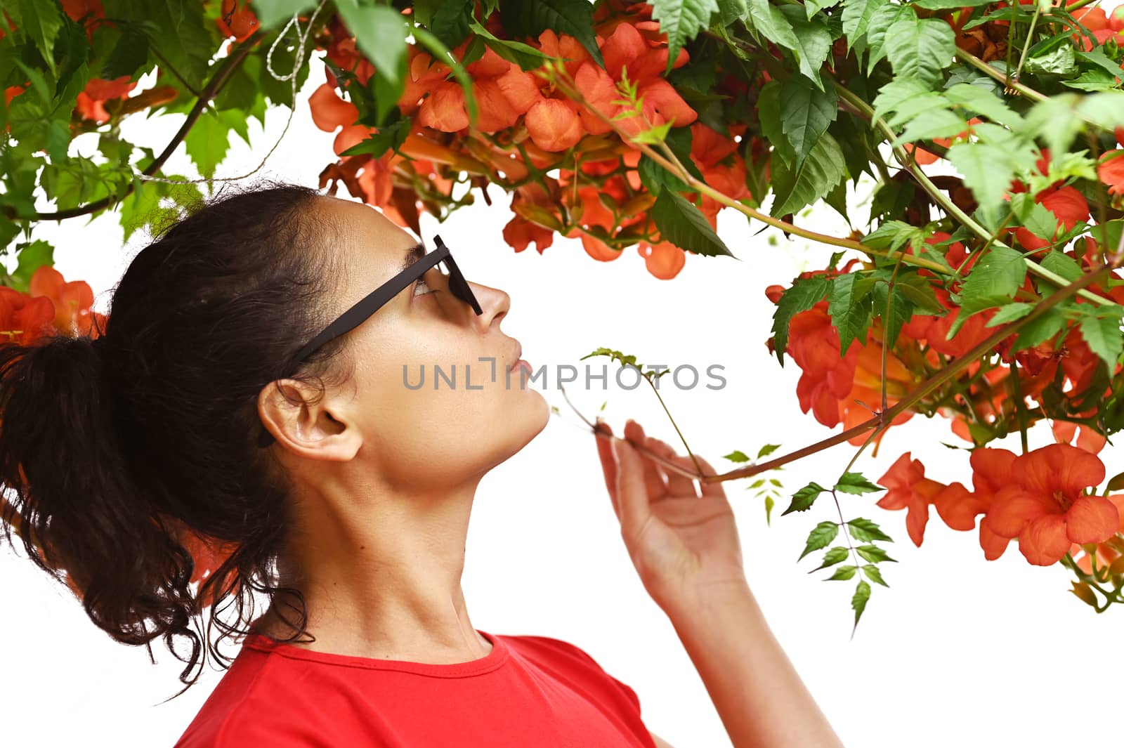 Beautiful young woman smelling red flowers in the park. Sarajevo, Bosnia and Herzegovina