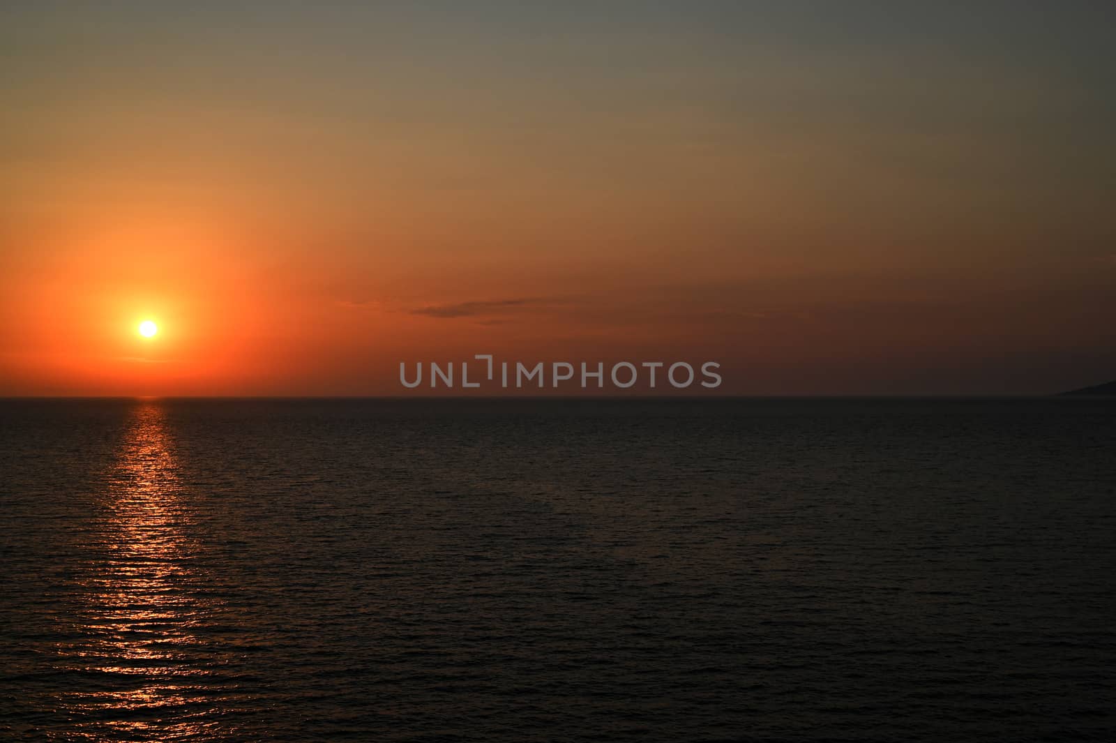 Red sunset over the sea, rich in dark clouds, rays of light, captured near Saranda, Albania