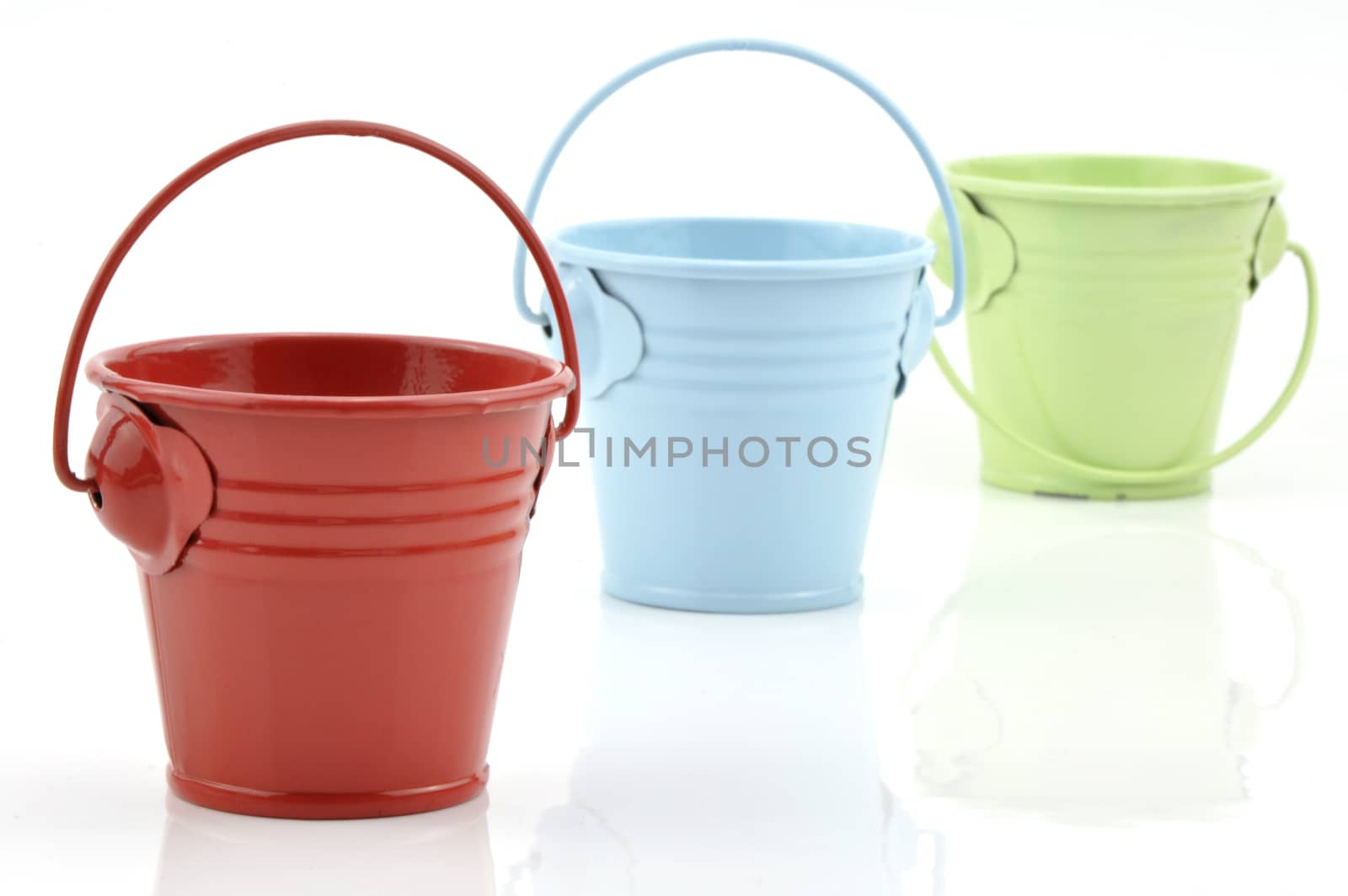 Three metal buckets of different colours with handle, isolated on white background