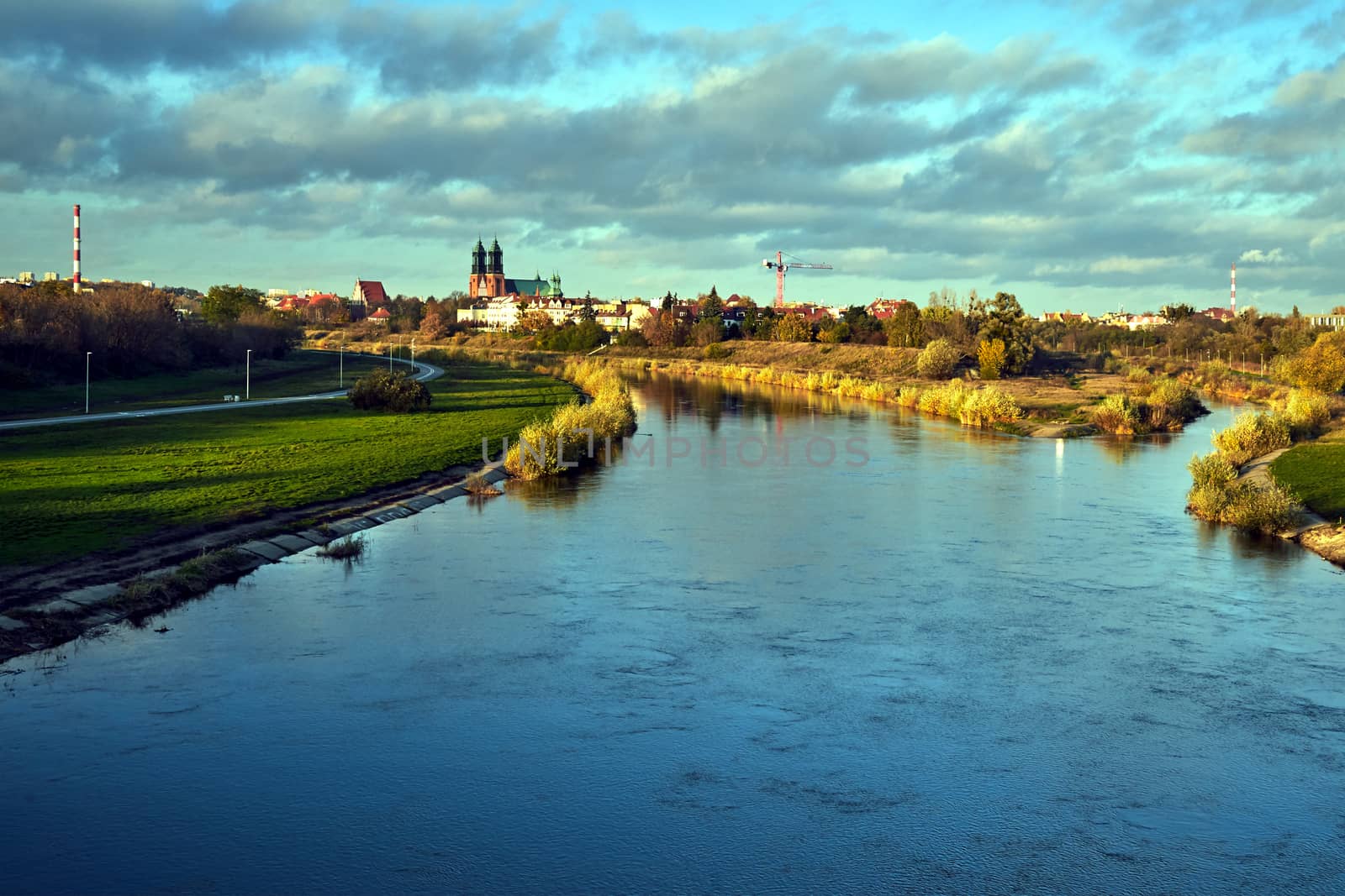 Urban landscape with river Warta and the cathedral towers in the fall in Poznan