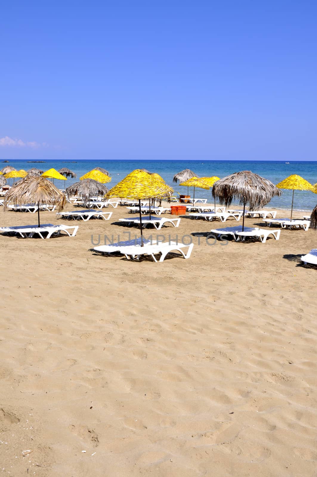 Handmade palm leaf and cane umbrellas on a beautiful Cyprus beach by mixeey