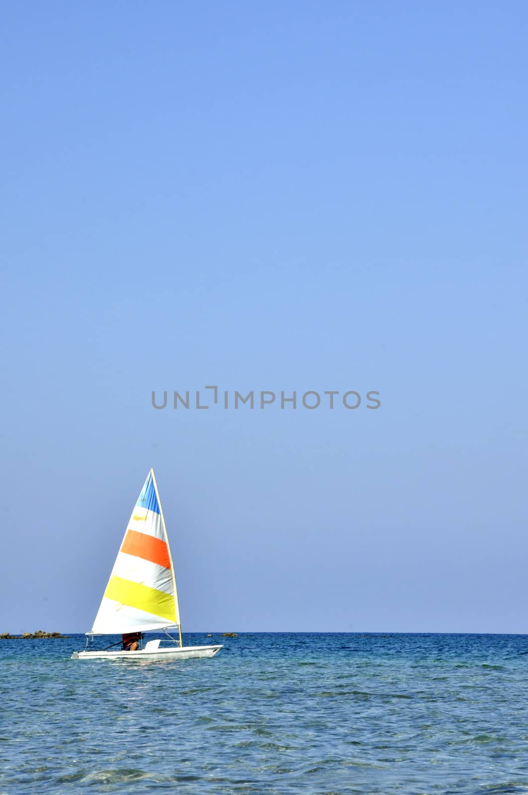 A colorful sailboat with a captain sails the Cyprus Sea during summer vacation