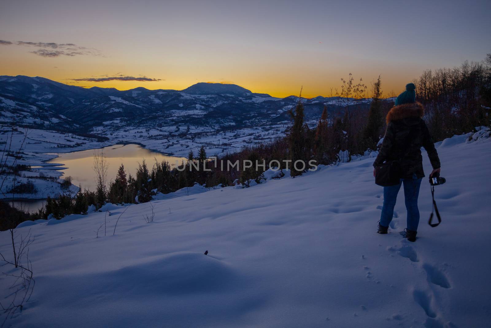 Photographers photographing winter lake mountain scene in sunset by adamr