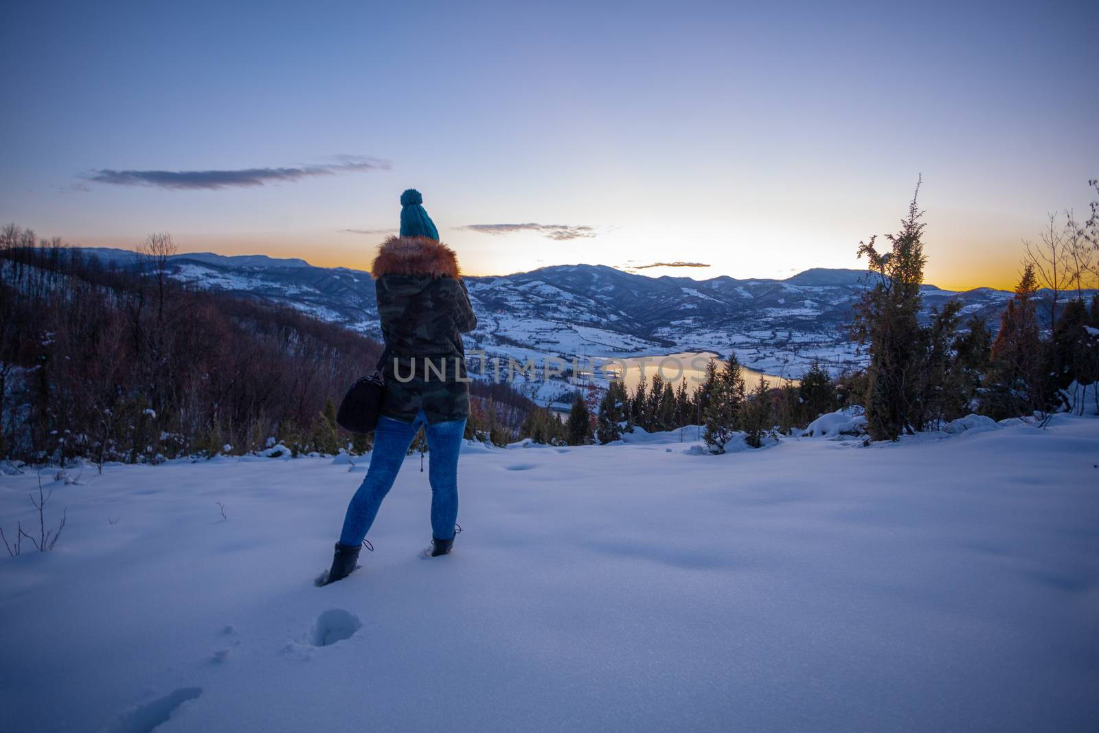 Photographers photographing winter lake mountain scene in sunset by adamr