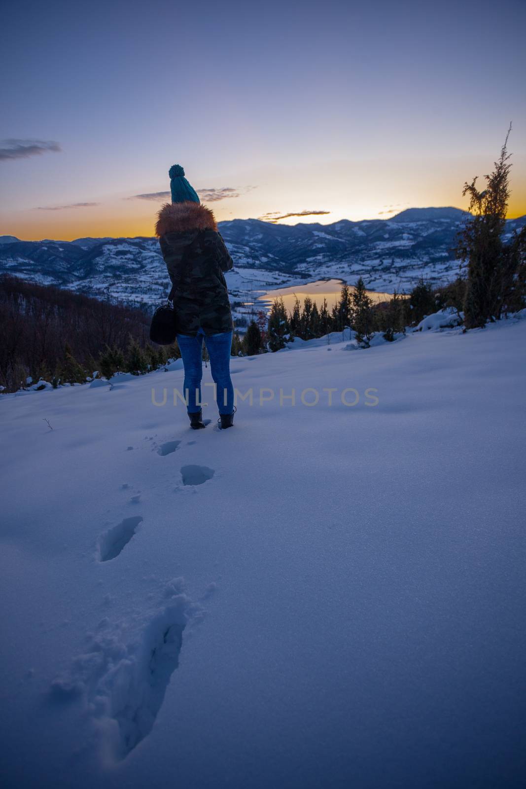 Photographers photographing winter lake mountain scene in sunset, alone in wilderness. Rovni, Valjevo, Serbia