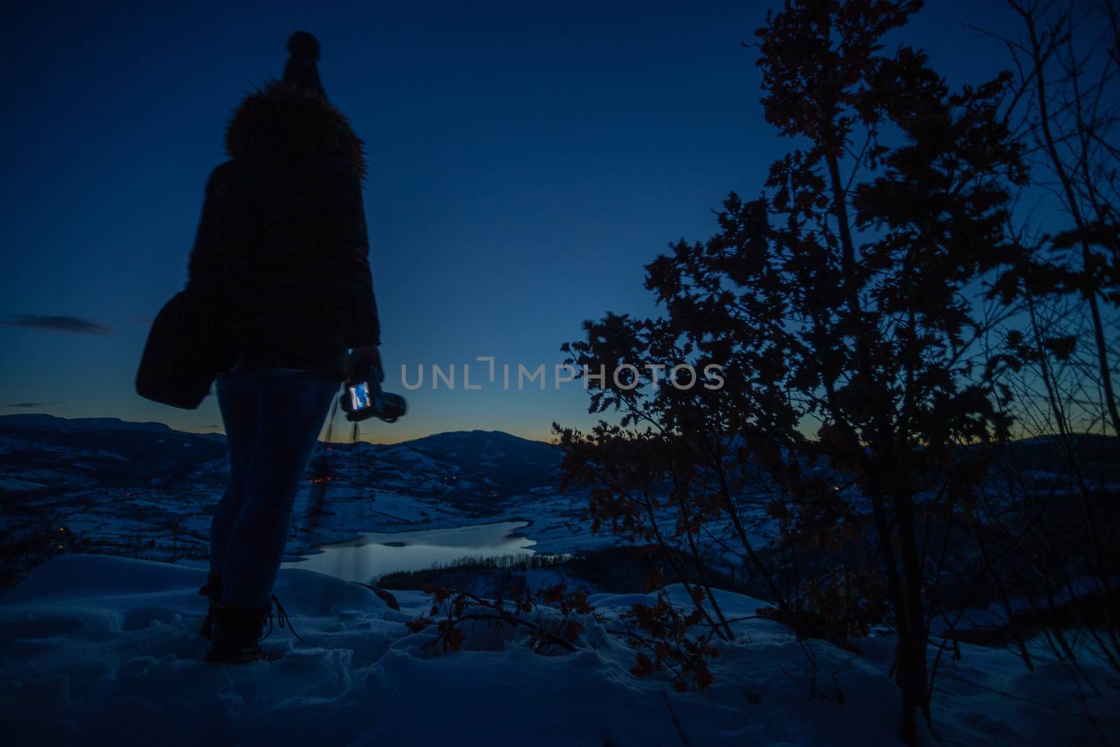 Photographers photographing winter lake mountain scene in sunset by adamr