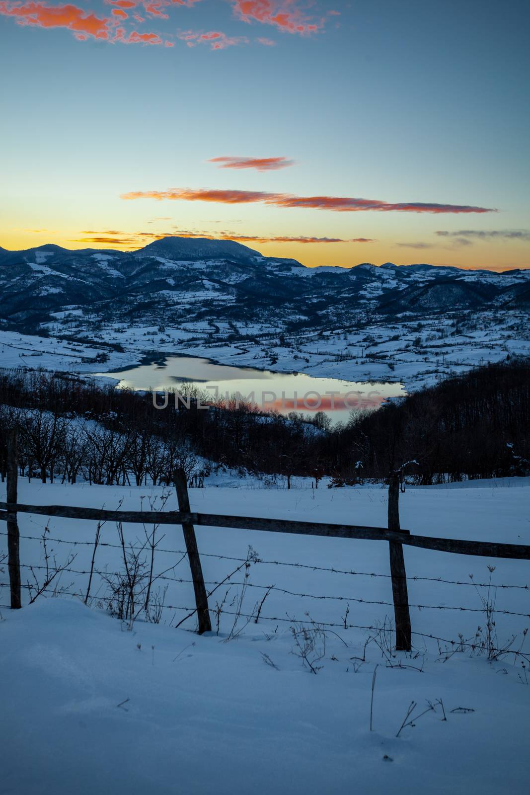 Colorful sunset evening at mountain lake in snow, beautiful natu by adamr